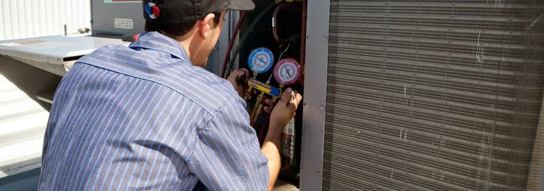 HVAC technician servicing a condenser unit in Bedford Heights